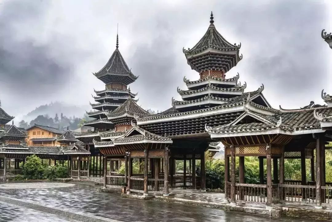 Yi Group Drum Tower and stage in Zhaoxing Dong Village, with villagers activities in front of the tower