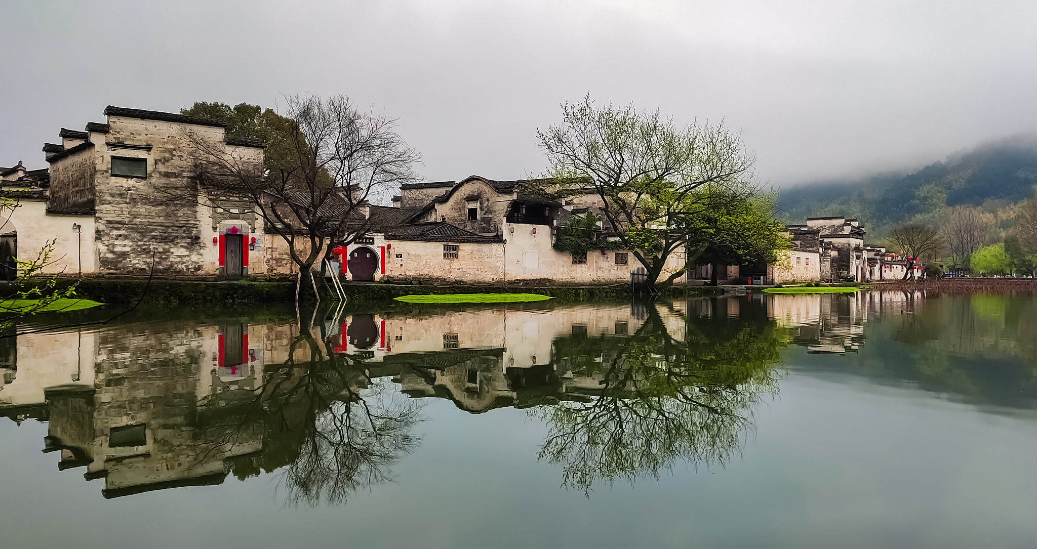 Scenery of Wuyuan, Jiangxi, featuring Huizhou architecture with rapeseed flower fields, beautiful ancient villages with white walls and black tiles under spring sunshine